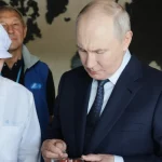 Presiden Rusia Vladimir Putin mencicipi produk saat mengunjungi kompleks pengolahan ikan di Pulau Iturup, Kepulauan Kuril. [Foto: AP]