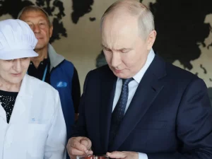 Presiden Rusia Vladimir Putin mencicipi produk saat mengunjungi kompleks pengolahan ikan di Pulau Iturup, Kepulauan Kuril. [Foto: AP]