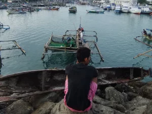 Perahu-perahu nelayan bersandar rapat di perairan pelabuhan.