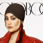 Agnez Mo mengenakan mantel kulit merah dan penutup kepala rajut di sampul majalah