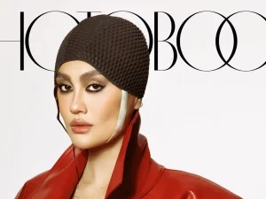 Agnez Mo mengenakan mantel kulit merah dan penutup kepala rajut di sampul majalah