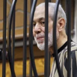 Ahmad Badreddin Hassoun berdiri di ruang sidang saat hakim membacakan vonis di Damaskus.