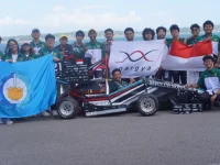 Anggota tim Anargya ITS berfoto bersama mobil balap listrik sambil membentangkan bendera Merah Putih dan panji kampus