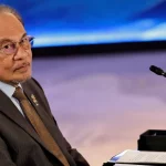 Perdana Menteri Malaysia Anwar Ibrahim mengenakan setelan gelap