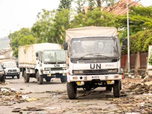 Iring-iringan truk bantuan kemanusiaan melintasi jalan yang rusak