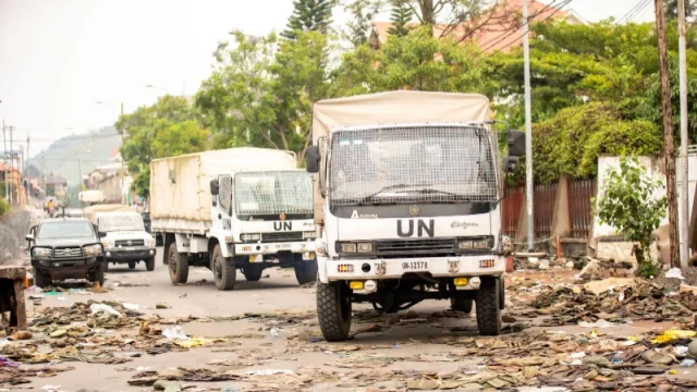 Iring-iringan truk bantuan kemanusiaan melintasi jalan yang rusak