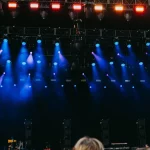 Ilustrasi panggung konser dengan lampu sorot