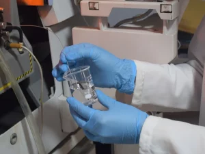 Peneliti menangani gelas kimia berisi sampel air di laboratorium