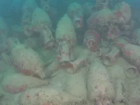 Ratusan guci keramik amphora tertumpuk di dasar laut, tertutup endapan dan lumut setelah terendam ribuan tahun