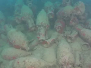 Ratusan guci keramik amphora tertumpuk di dasar laut, tertutup endapan dan lumut setelah terendam ribuan tahun