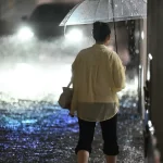 Warga melintasi kawasan yang terendam banjir di Jepang