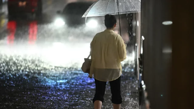 Warga melintasi kawasan yang terendam banjir di Jepang