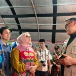 Pejabat BNPB berbincang dengan rombongan Kementerian Pemberdayaan Perempuan dan Perlindungan Anak di pos pendukung logistik bantuan.