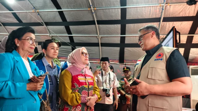 Pejabat BNPB berbincang dengan rombongan Kementerian Pemberdayaan Perempuan dan Perlindungan Anak di pos pendukung logistik bantuan.