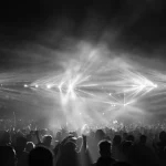 Kerumunan penonton konser di bawah sorot lampu panggung