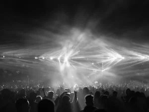 Kerumunan penonton konser di bawah sorot lampu panggung