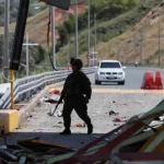 Seorang tentara berjalan di antara puing gerbang tol yang rusak akibat ledakan bom mobil di Cauca, Kolombia