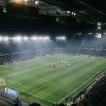 Tribun stadion sepak bola yang penuh penonton pada malam hari