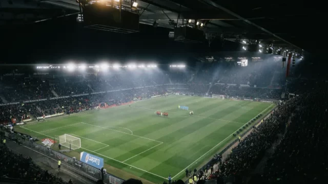 Tribun stadion sepak bola yang penuh penonton pada malam hari