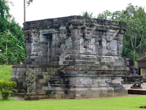 Candi Naga di Kompleks Candi Panataran, Blitar, dengan tubuh candi batu andesit berhias pahatan naga melingkar dan deretan figur penopang