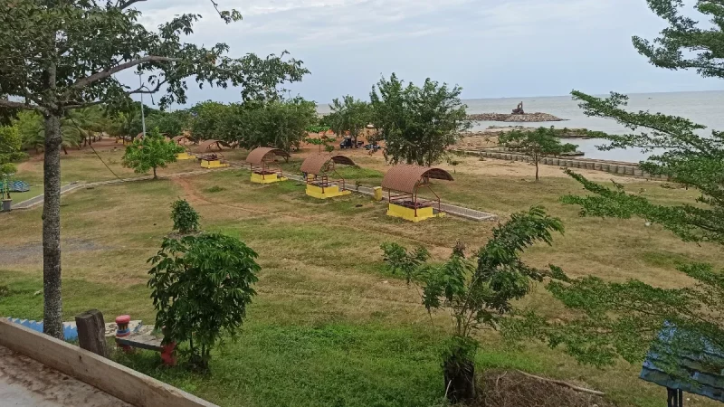 Pesisir Takisung di Kabupaten Tanah Laut dengan hamparan rumput dan laut di kejauhan.