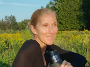 Celine Dion tersenyum di tengah ladang bunga liar