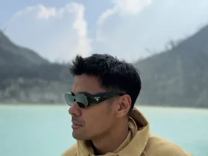 Chicco Jerikho berpose dengan latar danau kawah dan pegunungan saat syuting