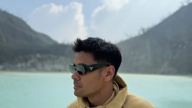 Chicco Jerikho berpose dengan latar danau kawah dan pegunungan saat syuting