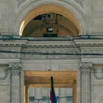 Gerbang batu bergaya klasik di pusat Kota Chisinau dengan bendera Moldova berkibar di belakangnya