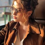 Cinta Laura duduk di kursi kereta api melihat ke luar jendela