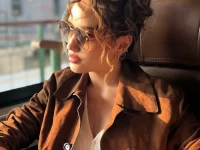 Cinta Laura duduk di kursi kereta api melihat ke luar jendela