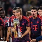 Penyerang Bayern Muenchen Harry Kane mengangkat trofi bersama rekan setim
