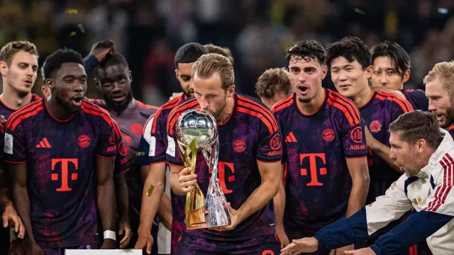 Penyerang Bayern Muenchen Harry Kane mengangkat trofi bersama rekan setim