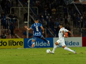 Dua pemain sepak bola berduel memperebutkan bola di lapangan stadion