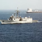 Kapal perang mengawal kapal tanker di laut