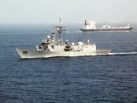 Kapal perang mengawal kapal tanker di laut