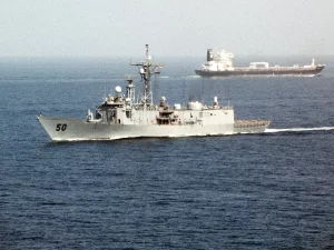 Kapal perang mengawal kapal tanker di laut
