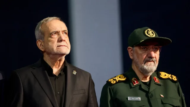 Presiden Iran Masoud Pezeshkian berdiri berdampingan dengan seorang pejabat militer