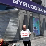 Seorang nasabah bank berunjuk rasa di depan kantor bank di Beirut