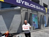 Seorang nasabah bank berunjuk rasa di depan kantor bank di Beirut