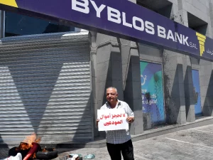 Seorang nasabah bank berunjuk rasa di depan kantor bank di Beirut