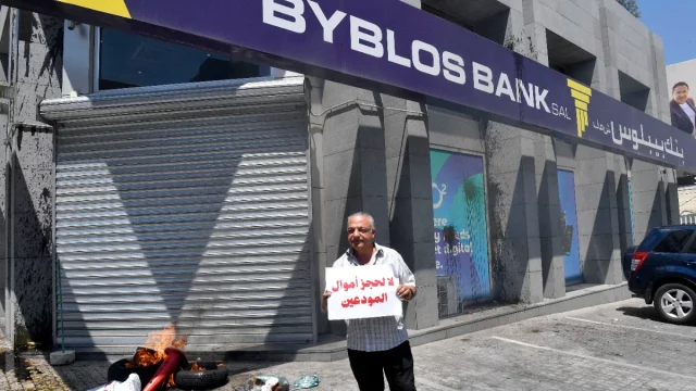 Seorang nasabah bank berunjuk rasa di depan kantor bank di Beirut