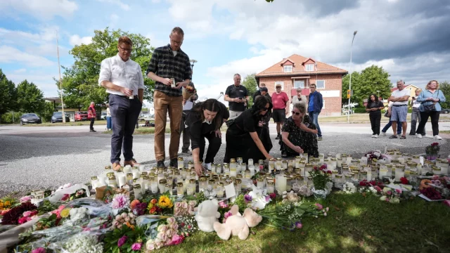 Warga meletakkan bunga dan lilin di tugu peringatan darurat depan sekolah