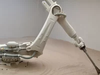 Lengan robot industri KUKA menjalankan karya The Beach buatan Roy Nachum.