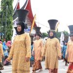Perempuan Minangkabau berbaju kurung basiba dan bertengkuluk tanduk dalam arak-arakan