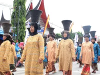 Perempuan Minangkabau berbaju kurung basiba dan bertengkuluk tanduk dalam arak-arakan