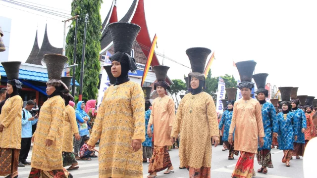 Perempuan Minangkabau berbaju kurung basiba dan bertengkuluk tanduk dalam arak-arakan