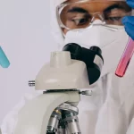 Petugas laboratorium memeriksa sampel menggunakan mikroskop