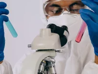 Petugas laboratorium memeriksa sampel menggunakan mikroskop