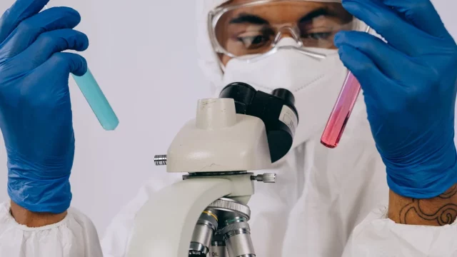 Petugas laboratorium memeriksa sampel menggunakan mikroskop